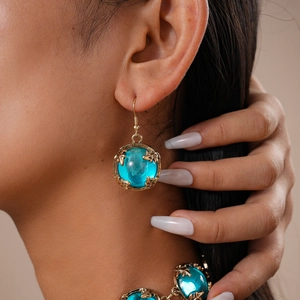 Gros plan d'un collier ras du cou vintage en résine et boucles d'oreilles bleues assorties