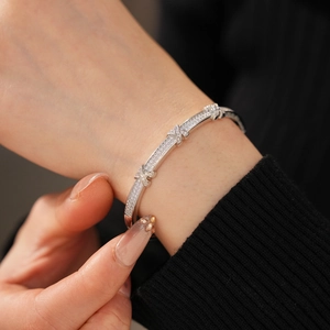 Macro shot of silver X-shaped cross links on a zircon-set bracelet with 18k gold plating