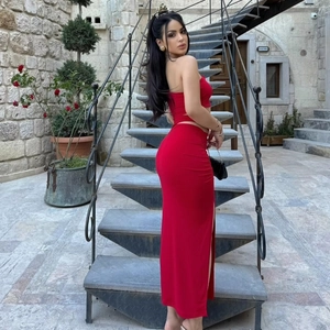 Detail of red two-piece slim set with side slit maxi skirt and tube top in outdoor setting