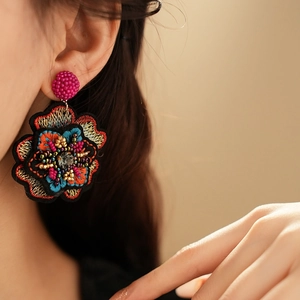 Ethnic style colorful floral embroidery earrings with beads shown on a female model