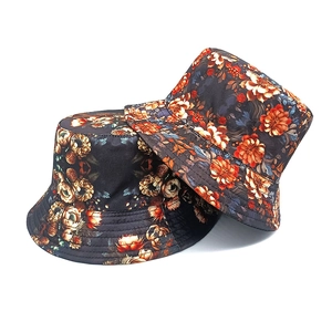 Detail of vintage floral print bucket hat with vibrant orange and beige flower patterns