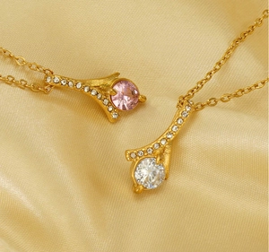 Detail of pink and white zircon necklaces on luxury champagne silk fabric texture