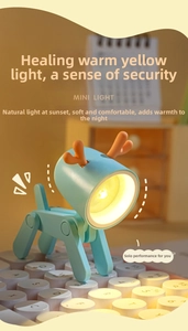 Adjustable mini LED deer night light in blue used as a phone holder on a white keyboard