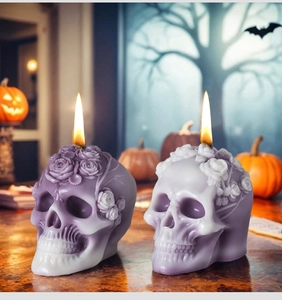 Detail of purple skull candles with rose patterns in a Halloween setting with pumpkins