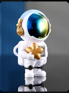 Dettaglio di statuina astronauta bianca con stella dorata e visiera del casco riflettente