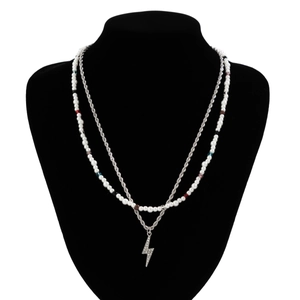 Detail of hip hop beaded necklace with a sparkling lightning pendant on a black bust display