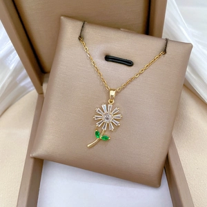 Elegant gold necklace with sparkling sunflower pendant featuring green and white crystals