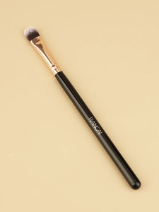 Detail of tongue-shaped concealer brush with bicolored bristles and a rose gold ferrule