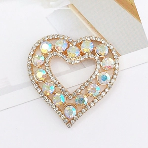 Close-up of heart-shaped gold accessory with AB rhinestones and pavé crystal edges