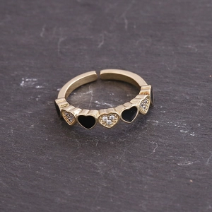 Detail of gold heart ring with black enamel inlay and sparkling white crystals