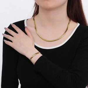 Ensemble collier et bracelet Figaro pour femme en acier titane doré sur mannequin