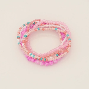 Detail shot of multi-layered bohemian beaded bracelets in pink, blue and pearl white