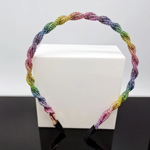 Detailed shot of rainbow rhinestone twisted headband on a white display block