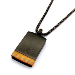 Detail of square natural tiger eye pendant with dark metal hardware and box chain necklace