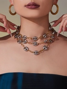 Détail du collier à trois rangs mariner bicolore et boucles d'oreilles créoles dorées