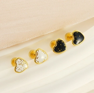 Macro shot of French style heart studs with black and white drip oil and gold sequins
