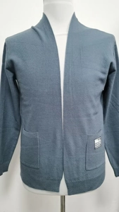 Close-up of navy blue knit cardigan featuring side pockets and a branded detail tag