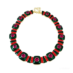 Vintage gold necklace with green rectangular inserts and red gemstones on white background