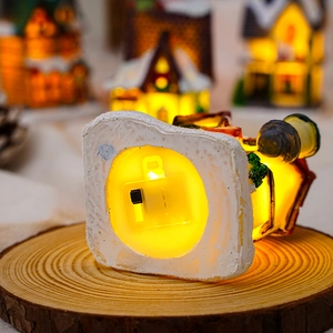 Detail view of the power switch and warm LED light base of the resin Christmas house