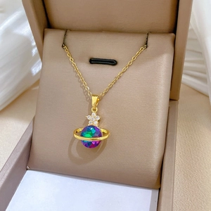 Macro detail of gold Saturn pendant with iridescent bead and star ornament on a chain