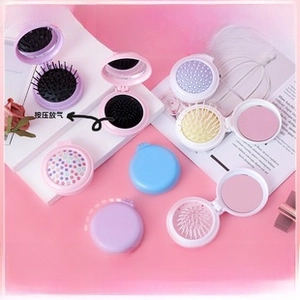 Macro detail of portable macaroon cushion hairbrush with built-in folding makeup mirror