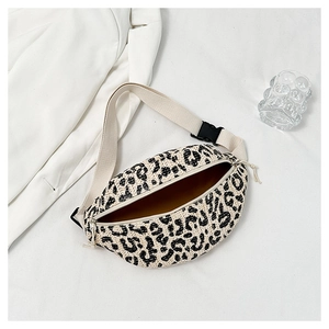 Flat lay of leopard print straw fanny pack with adjustable strap and buckle closure