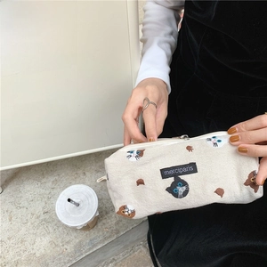 Detail of canvas pencil case with cute cat embroidery and zipper handle