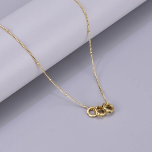 Minimalist gold necklace featuring interlocking triple rings and green zircon stones
