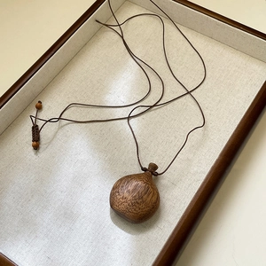 Collana vintage bohémien con ciondolo a bottiglia in legno intagliato e nappe