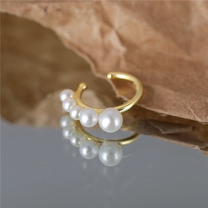 Elegant gold S925 sterling silver ear cuff with five graduated white pearls on brown paper