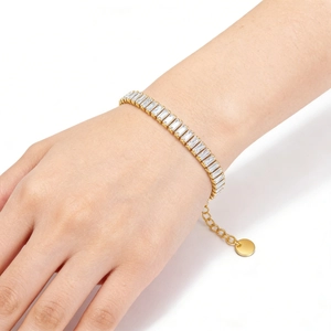 Macro detail of a gold titanium steel bracelet featuring radiant rectangular zircon stones