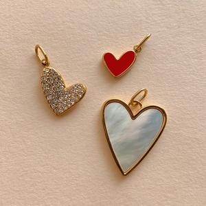 Golden heart pendants featuring red enamel, crystals, and mother of pearl inlay