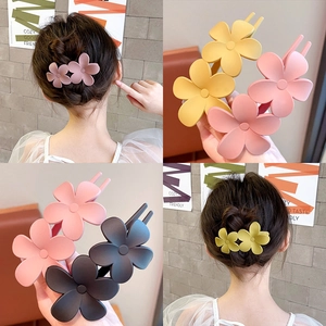 Ensemble de pinces à cheveux fleurs mates colorées présentées sur modèle et à la main