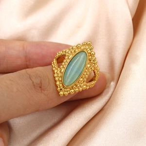 Vintage gold ring with green cat eye stone on pink silk background for women