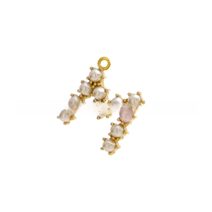 Macro detail of gold-plated letter M pendant with white and pink shell pearls
