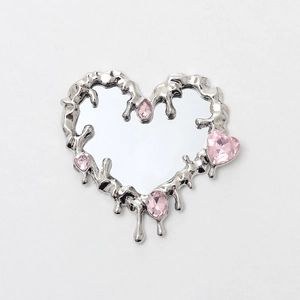 Detail of silver liquid metal heart mirror with pink rhinestone accents and y2k style