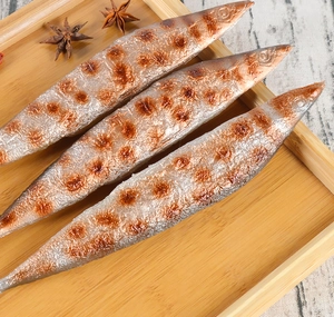 Three realistic PVC grilled saury fish models displayed in a bamboo tray with spices