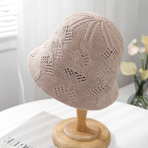 Beige hollow knit bucket hat with textured floral pattern and wavy brim for summer sun protection