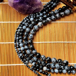 Macro view of multi-size natural snowflake obsidian round beads for DIY jewelry making