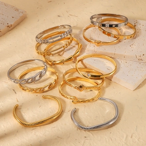 Set of 18K gold and silver stainless steel bangles with geometric textures and heart charms