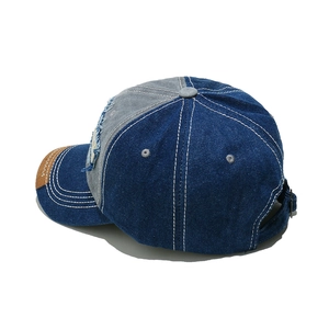Detail of vintage denim baseball cap showing contrast stitching and worn fabric patches