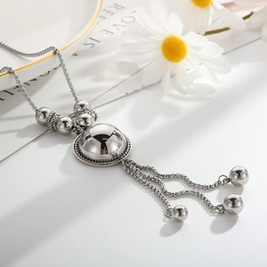 Macro detail of silver stainless steel necklace with sphere pendants and fringe chains
