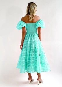 Detail of mint green off-shoulder dress featuring tiered skirt and jacquard plaid texture