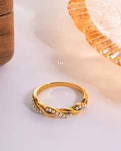 Detail of gold twisted stainless steel ring with elegant white pearl inlays and texture