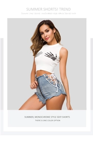 Dettaglio degli shorts in denim a vita alta con stringhe laterali e orlo a frange