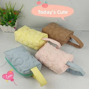 Detailed view of quilted puff floral makeup bags in yellow, blue, pink, and brown