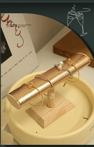 Macro detail of champagne gold leather beam and beige tray for jewelry display