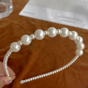 Macro view of white gradient pearl headband on brown velvet background for hair styling