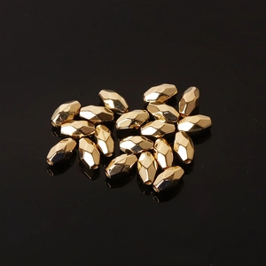 Golden faceted CCB diamond spacer beads for DIY jewelry making on a black reflective surface