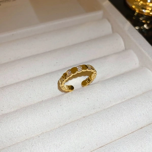 Macro view of gold plated oval butterfly ring featuring inlaid zircon stones on textured band